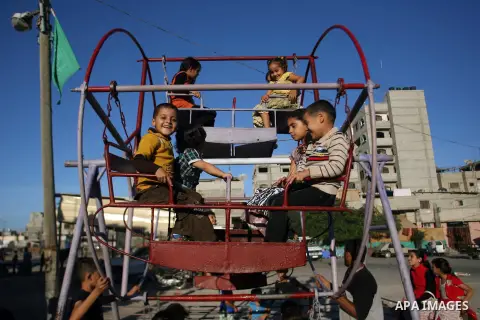 Palestinian children enjoy a ride during the third day of Eid al-Adha in Rafah refugee camp in the southern Gaza Strip on, 28 October 2012. Eid al-Adha, or the Feast of the Sacrifice, is celebrated to commemorate the Pro...