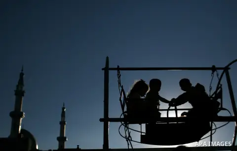 Palestinian children enjoy a ride during the third day of Eid al-Adha in Rafah refugee camp in the southern Gaza Strip on, 28 October 2012. Eid al-Adha, or the Feast of the Sacrifice, is celebrated to commemorate the Pro...
