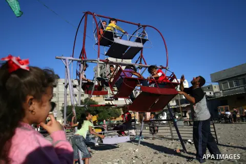 Palestinian children enjoy a ride during the third day of Eid al-Adha in Rafah refugee camp in the southern Gaza Strip on, 28 October 2012. Eid al-Adha, or the Feast of the Sacrifice, is celebrated to commemorate the Pro...