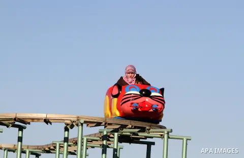Palestinians enjoy themselves at an amusement park in Gaza City as the Muslim world celebrates the third day of the Eid al-Adha holiday on October 28, 2012. Eid al-Adha or "Feast of the Sacrifice" marks the end of the an...