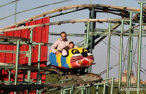 Palestinians enjoy themselves at an amusement park in Gaza City as the Muslim world celebrates the third day of the Eid al-Adha holiday on October 28, 2012. Eid al-Adha or "Feast of the Sacrifice" marks the end of the an...