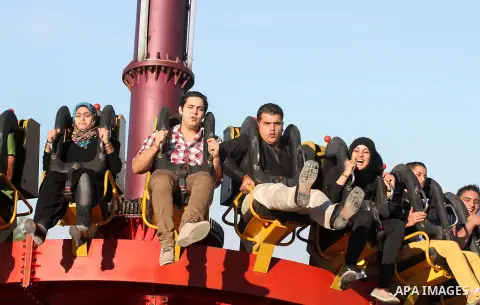 Palestinians enjoy themselves at an amusement park in Gaza City as the Muslim world celebrates the third day of the Eid al-Adha holiday on October 28, 2012. Eid al-Adha or "Feast of the Sacrifice" marks the end of the an...