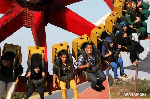 Palestinians enjoy themselves at an amusement park in Gaza City as the Muslim world celebrates the third day of the Eid al-Adha holiday on October 28, 2012. Eid al-Adha or "Feast of the Sacrifice" marks the end of the an...