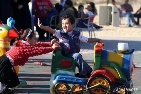 Palestinians enjoy themselves at an amusement park in Gaza City as the Muslim world celebrates the third day of the Eid al-Adha holiday on October 28, 2012. Eid al-Adha or "Feast of the Sacrifice" marks the end of the an...