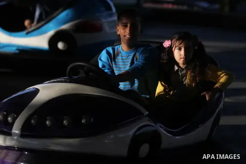 Palestinians enjoy themselves at an amusement park in Gaza City as the Muslim world celebrates the third day of the Eid al-Adha holiday on October 28, 2012. Eid al-Adha or "Feast of the Sacrifice" marks the end of the an...