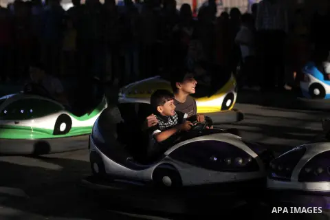 Palestinians enjoy themselves at an amusement park in Gaza City as the Muslim world celebrates the third day of the Eid al-Adha holiday on October 28, 2012. Eid al-Adha or "Feast of the Sacrifice" marks the end of the an...