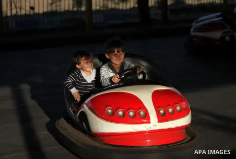 Palestinians enjoy themselves at an amusement park in Gaza City as the Muslim world celebrates the third day of the Eid al-Adha holiday on October 28, 2012. Eid al-Adha or "Feast of the Sacrifice" marks the end of the an...