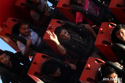 Palestinians enjoy themselves at an amusement park in Gaza City as the Muslim world celebrates the third day of the Eid al-Adha holiday on October 28, 2012. Eid al-Adha or "Feast of the Sacrifice" marks the end of the an...