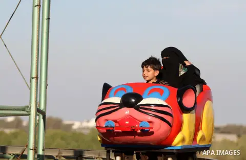 Palestinians enjoy themselves at an amusement park in Gaza City as the Muslim world celebrates the third day of the Eid al-Adha holiday on October 28, 2012. Eid al-Adha or "Feast of the Sacrifice" marks the end of the an...