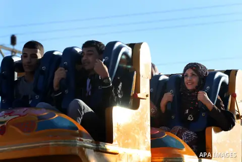 Palestinians enjoy themselves at an amusement park in Gaza City as the Muslim world celebrates the third day of the Eid al-Adha holiday on October 28, 2012. Eid al-Adha or "Feast of the Sacrifice" marks the end of the an...