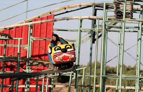 Palestinians enjoy themselves at an amusement park in Gaza City as the Muslim world celebrates the third day of the Eid al-Adha holiday on October 28, 2012. Eid al-Adha or "Feast of the Sacrifice" marks the end of the an...