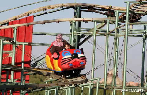 Palestinians enjoy themselves at an amusement park in Gaza City as the Muslim world celebrates the third day of the Eid al-Adha holiday on October 28, 2012. Eid al-Adha or "Feast of the Sacrifice" marks the end of the an...