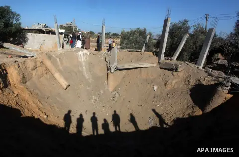 Palestinians inspect the damage to a building following an Israeli attack in al-Bureij, in the center of the Gaza Strip on October 29, 2012. Gaza militants fired 11 rockets over the border overnight in response to two la...