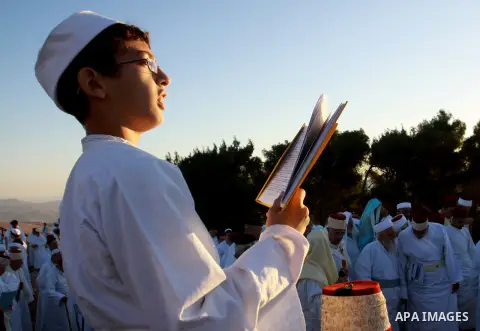 A Samaritan child wrapped in a prayer shawl participates in the pilgrimage for the holy day of the Tabernacles or Sukkot at the religion's holiest site on the top of Mount Gerizim near the West Bank city of Nablus, on Oc...
