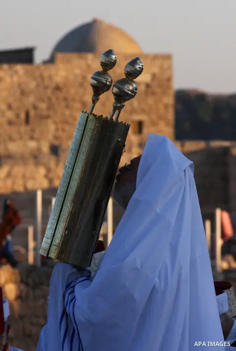 A Priest of the ancient Samaritan community, wrapped in a prayer shawl, holds up a Tora scroll during the pilgrimage for the holy day of the Tabernacles or Sukkot at the religion's holiest site on the top of Mount Gerizi...