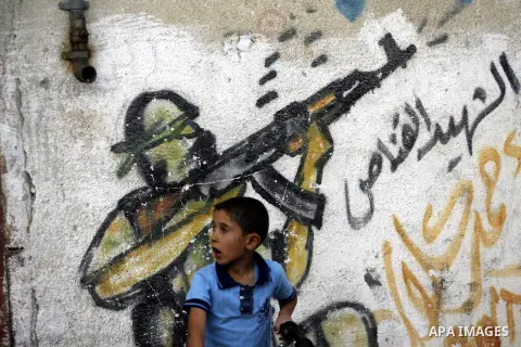 A Palestinian child plays in front of a wall graffiti, in Rafah refugee camp southern the Gaza strip, Oct. 30, 2012. In the aftermath of the Israeli military Operation Cast Lead in 2008/2009, Palestinian refugees in Gaza...
