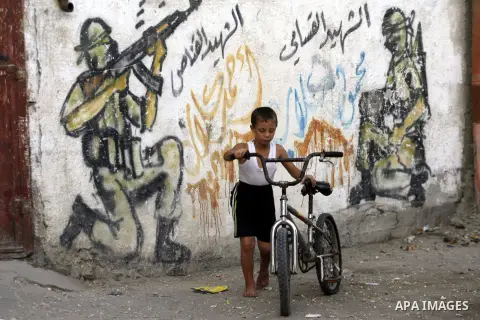 A Palestinian child plays in front of a wall graffiti, in Rafah refugee camp southern the Gaza strip, Oct. 30, 2012. In the aftermath of the Israeli military Operation Cast Lead in 2008/2009, Palestinian refugees in Gaza...