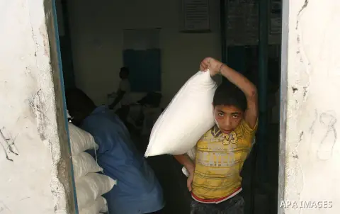 A Palestinian child carries food aid receiving from UN Relief and Works Agency (UNRWA) warehouse, in Rafah refugee camp southern the Gaza strip, Oct. 30, 2012. In the aftermath of the Israeli military Operation Cast Lead...