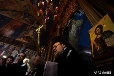 A Palestinian priest prays on Christian Hossam Al-Tawil during his funeral at the Church of Saint Porphyrius in Gaza city on Nov. 01, 2012. Al-Tawil passed away in Egypt after seeking medical treatment in the country. He...