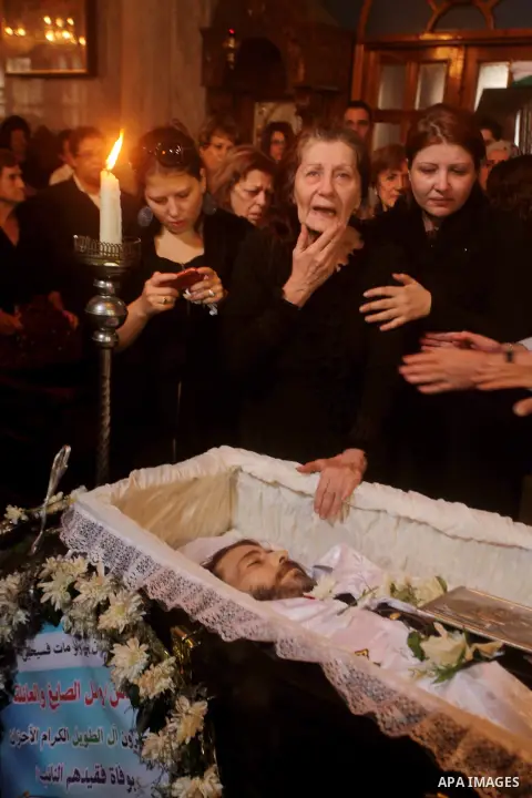 Palestinian relatives of Christian Hossam Al-Tawil mourn on his body during his funeral at the Church of Saint Porphyrius in Gaza city on Nov. 01, 2012. Al-Tawil passed away in Egypt after seeking medical treatment in th...