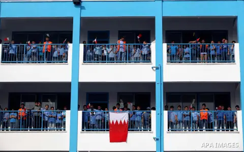 Palestinian school boys hold Bahraini flags during the visit of Secretary General of the Royal Charity Organization in the Kingdom of Bahrain, Mustafa al-Sayed to a UNRWA (United Nations Relief and Works Agency) school f...