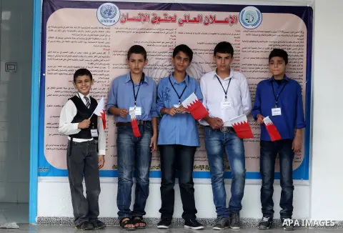 Palestinian school boys hold Bahraini flags during the visit of Secretary General of the Royal Charity Organization in the Kingdom of Bahrain, Mustafa al-Sayed to a UNRWA (United Nations Relief and Works Agency) school f...