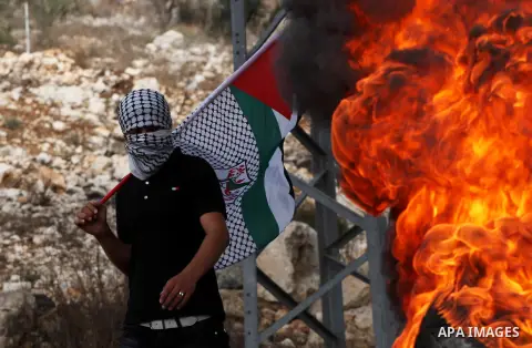 A Palestinian protester holds national flag during a demonstration marking the anniversary of Balfour Declaration, in the village of Kfar Qaddum, near the West Bank city of Nablus on November 02, 2012. The Balfour Declar...