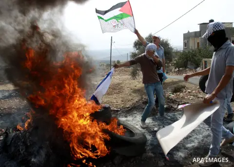 Palestinian protesters burn the Israeli flag during a demonstration marking the anniversary of Balfour Declaration, in the village of Kfar Qaddum, near the West Bank city of Nablus on November 02, 2012. The Balfour Decla...