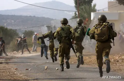 Israeli soldiers chase Palestinian protesters during clashes following a demonstration marking the anniversary of Balfour Declaration, in the village of Kfar Qaddum, near the West Bank city of Nablus on November 02, 2012...