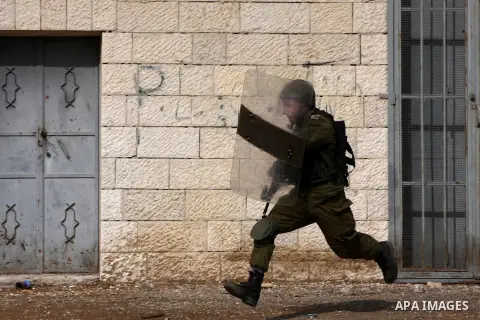 An Israeli soldier chases Palestinian protesters during clashes following a demonstration marking the anniversary of Balfour Declaration, in the village of Kfar Qaddum, near the West Bank city of Nablus on November 02, 2...