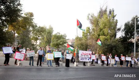 Palestinian and foreign activists hold Palestinian flags and placards during a protest against land confiscation in the neighborhood of Sheikh Jarrah in the east Jerusalem on 02 November 2012. Photo by Mahfouz Abu Turk
