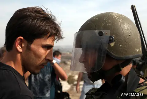 A Palestinian demonstrator confronts an Israeli soldier during a protest against the confiscation of Palestinian land by Israel in the West Bank village of Nabi Saleh near Ramallah on November 2, 2012. Photo by Issam Rim...