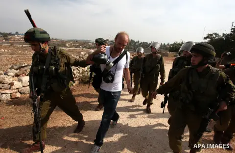 Israeli soldiers detain a foreign photographer during a protest against the confiscation of Palestinian land by Israel in the West Bank village of Nabi Saleh near Ramallah on November 2, 2012. Photo by Issam Rimawi