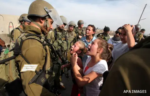 Palestinian girls scuffle with Israeli soldiers during a protest against the expansion of the nearby Jewish settlement of Halamish, in the West Bank village of Nabi Saleh near Ramallah, Friday, Nov 2, 2012. Photo by Issa...