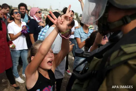 Palestinian girls scuffle with Israeli soldiers during a protest against the expansion of the nearby Jewish settlement of Halamish, in the West Bank village of Nabi Saleh near Ramallah, Friday, Nov 2, 2012. Photo by Issa...