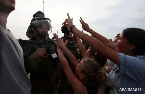 Palestinian girls scuffle with Israeli soldiers during a protest against the expansion of the nearby Jewish settlement of Halamish, in the West Bank village of Nabi Saleh near Ramallah, Friday, Nov 2, 2012. Photo by Issa...