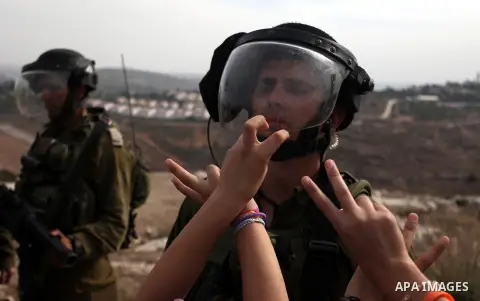 Palestinian girls scuffle with Israeli soldiers during a protest against the expansion of the nearby Jewish settlement of Halamish, in the West Bank village of Nabi Saleh near Ramallah, Friday, Nov 2, 2012. Photo by Issa...