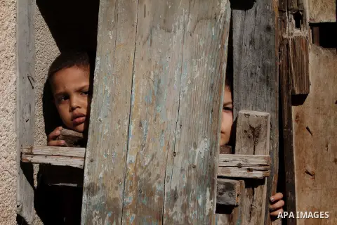 Palestinian children peer through a wooden door at the Shati Palestinian refugee camp in Gaza City on November 3, 2012. The issue of refugees is one of the thorniest elements of the Palestinian-Israeli conflict, with the...