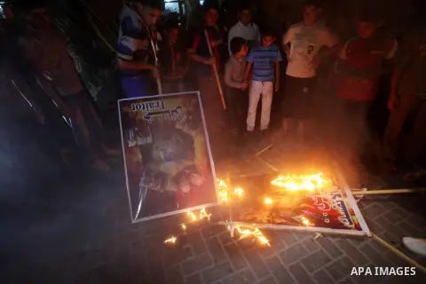 A Hamas supporter burns a poster depicting Palestinian President Mahmoud Abbas during a protest in Jabalya in the northern Gaza Strip November 3, 2012. Abbas made a rare if symbolic concession to Israel on Thursday, sayi...