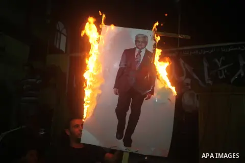 A Hamas supporter burns a poster depicting Palestinian President Mahmoud Abbas during a protest in Jabalya in the northern Gaza Strip November 3, 2012. Abbas made a rare if symbolic concession to Israel on Thursday, sayi...