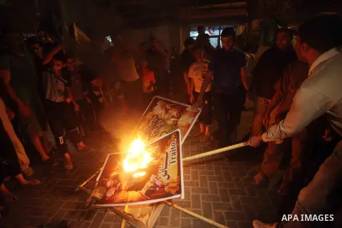 A Hamas supporter burns a poster depicting Palestinian President Mahmoud Abbas during a protest in Jabalya in the northern Gaza Strip November 3, 2012. Abbas made a rare if symbolic concession to Israel on Thursday, sayi...