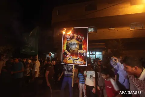 A Hamas supporter burns a poster depicting Palestinian President Mahmoud Abbas during a protest in Jabalya in the northern Gaza Strip November 3, 2012. Abbas made a rare if symbolic concession to Israel on Thursday, sayi...
