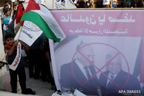 El-Ahrar party supporters carry placards and posters of Palestinian President Mahmoud Abbas with Israeli leaders during a demonstration in Gaza city on November 6, 2012. Protestors gathered to express their anger towards...