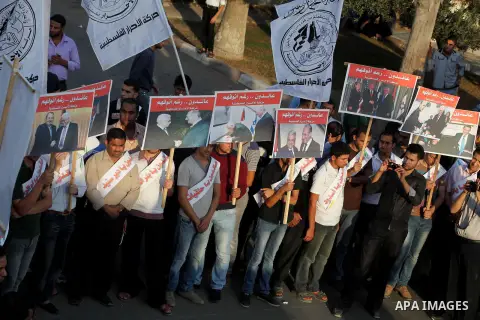 El-Ahrar party supporters carry placards and posters of Palestinian President Mahmoud Abbas with Israeli leaders during a demonstration in Gaza city on November 6, 2012. Protestors gathered to express their anger towards...