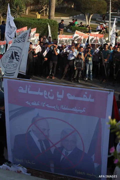 El-Ahrar party supporters carry placards and posters of Palestinian President Mahmoud Abbas with Israeli leaders during a demonstration in Gaza city on November 6, 2012. Protestors gathered to express their anger towards...