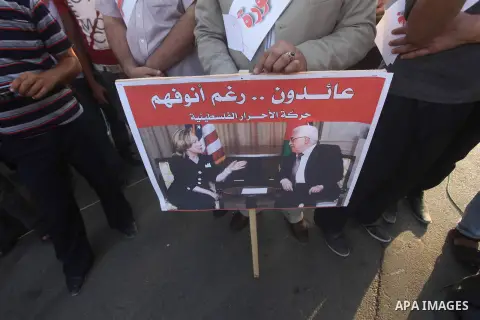 El-Ahrar party supporters carry placards and posters of Palestinian President Mahmoud Abbas with Israeli leaders during a demonstration in Gaza city on November 6, 2012. Protestors gathered to express their anger towards...