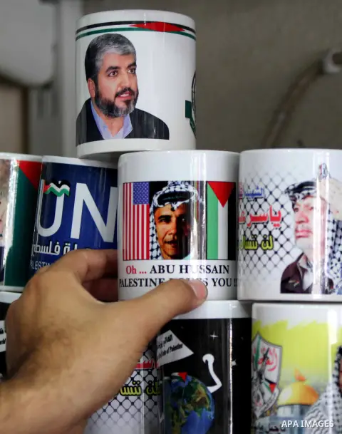 A Palestinian shop owner displays mugs for sale with portraits of leaders including US President Barack Obama, at a souvenir shop in Gaza City on Nov. 07, 2012. Democratic President Obama defeated Republican candidate Mi...