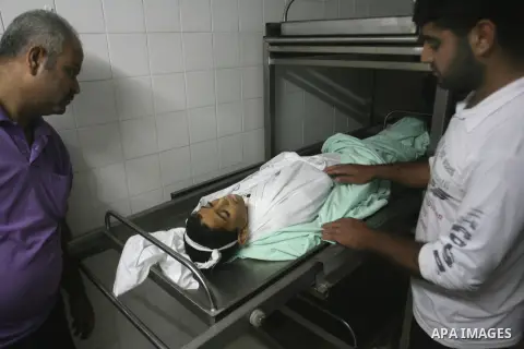 Palestinians look at the body of Ahmed Abu Dagah, who was killed by gunfire from Israeli forces, at the morgue of a hospital in Khan Younis in the southern Gaza Strip November 8, 2012. Gunfire from Israeli forces killed...