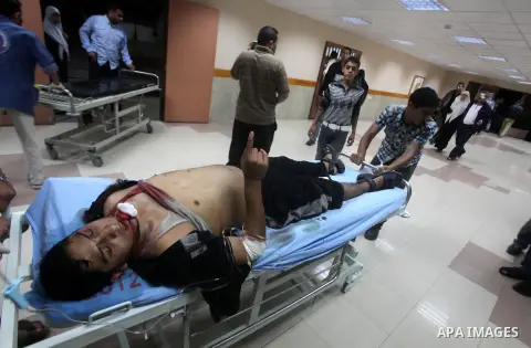 A wounded Palestinian is wheeled on a stretcher at a hospital in Gaza City following Israeli shelling November 10, 2012. Israeli tank shells killed at least two Palestinians and wounded 20 in the Gaza Strip on Saturday a...