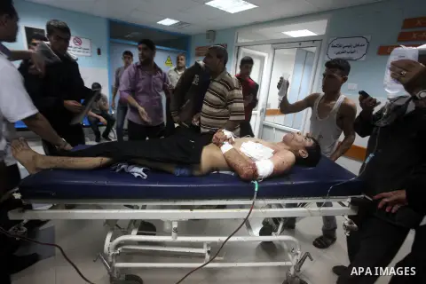 A wounded Palestinian is wheeled on a stretcher at a hospital in Gaza City following Israeli shelling November 10, 2012. Israeli tank shells killed at least two Palestinians and wounded 20 in the Gaza Strip on Saturday a...